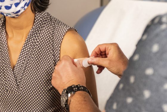 A person has a bandaid applied after COVID vaccination